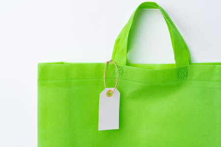 Blank paper tag with shopper paperbag on white backgroundの写真素材