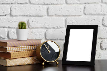 Books with picture frame on wooden table
