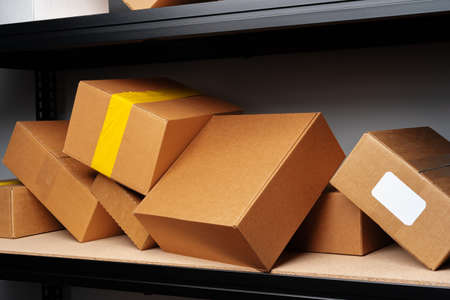 Rows of shelves with cardboard boxes in modern warehouse