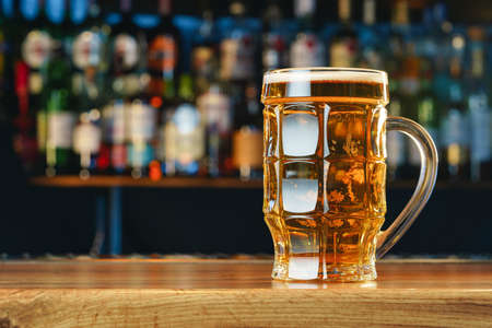 Fresh cold beer in glass on bar backgroundの写真素材