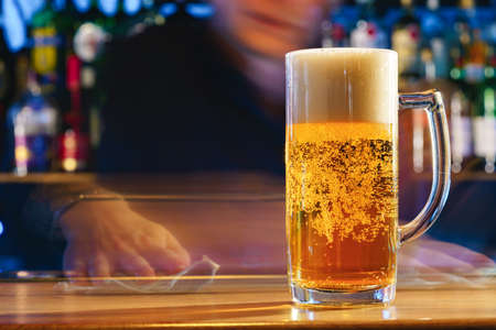 Fresh cold beer in glass on bar backgroundの写真素材