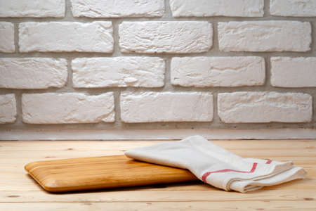 Cutting board with cotton napkin on wooden tableの写真素材