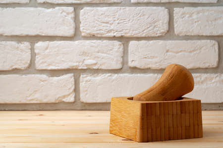 Wooden mortar with pestle on wooden background