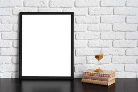 Books with picture frame on wooden table
