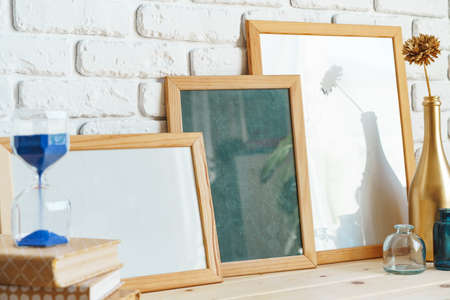 Wooden frame mockup on table with modern vase and booksの写真素材