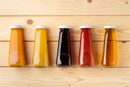 Juice bottles on wooden background flat layの写真素材