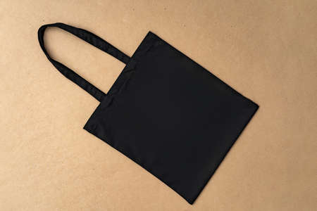 Black textile shopping bag on beige background flat layの写真素材