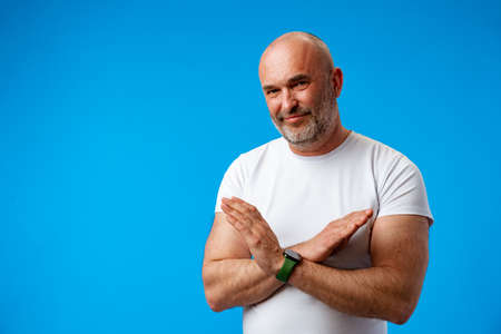 Middle age handsome grey-haired man over blue background doing stop signの写真素材