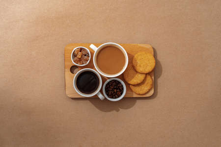 Top view of the wooden tray with coffee cup on beige backgroundの写真素材