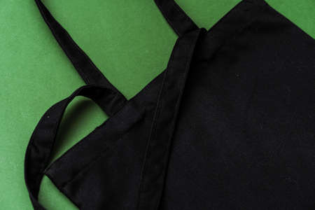 Textile shopping bag on green background flat layの写真素材