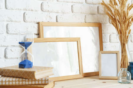 Photo frames on a brick wall background on the table with wheat ears in vase