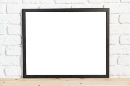 Photo frames on floor over white brick wallの写真素材