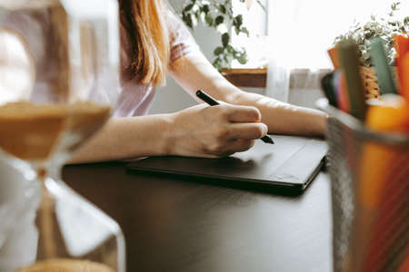 Close up of female graphic designer drawing sketches on graphic tabletの写真素材