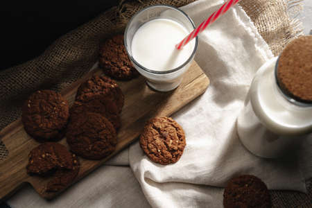 Glass of milk and cookies on table