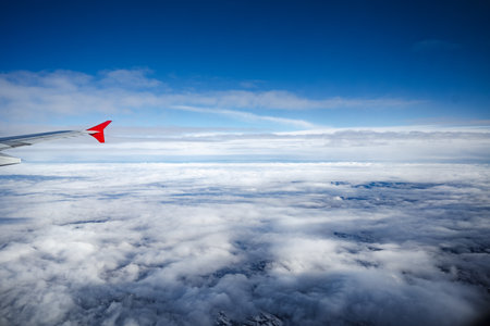 Aircraft wing above beautiful clouds and blue skyの写真素材