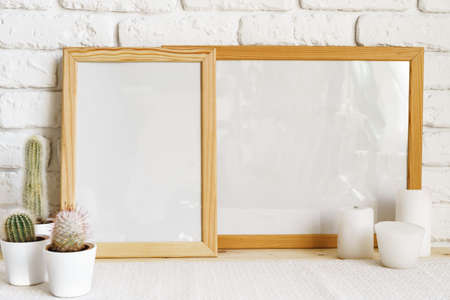 Square wooden photo frame and cactus plants on the table