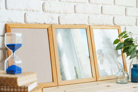 Wooden frame mockup on table with modern vase and booksの写真素材