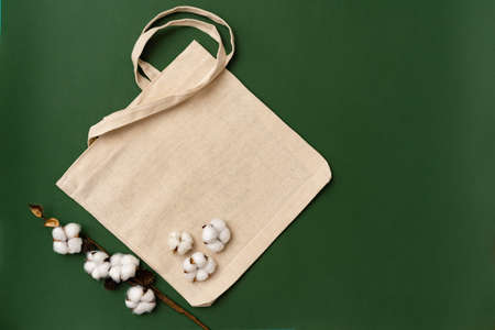 Textile eco bag and cotton flowers on paper background.の写真素材