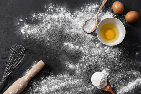 Preparation for baking. Eggs and flour on black backgroundの写真素材