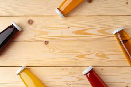 Juice bottles on wooden background flat lay