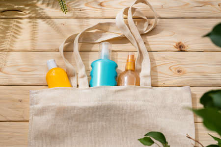 Sunscreen cream bottles in beach bag on wooden backgroundの写真素材