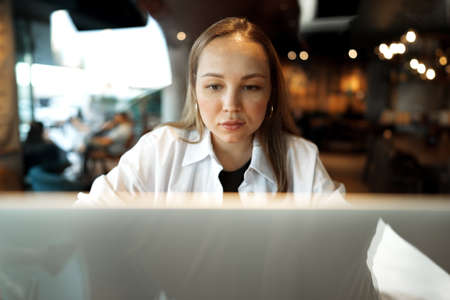 Young businesswoman sitting in a cafe and working with laptopの写真素材