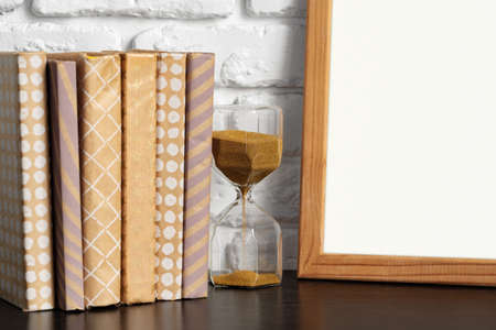 Books with picture frame on wooden table