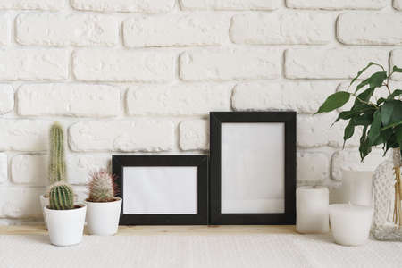 Square wooden photo frame and cactus plants on the table