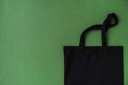 Textile shopping bag on green background flat layの写真素材