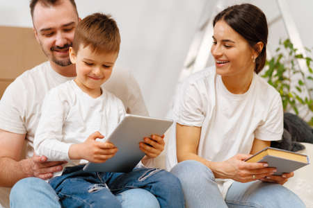 Portrait of happy family with cardboard boxes in new house at moving day