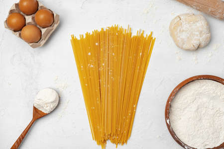 Raw egg pasta with flour on white background top viewの写真素材