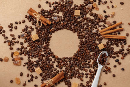 Roasted coffee beans scattered on beige background top viewの写真素材