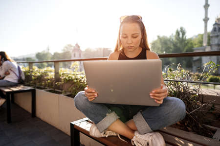 Young blonde businesswoman using laptop working at the terrace in Istanbulの写真素材