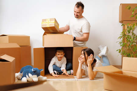 Young parents and son having fun during moving day to new house