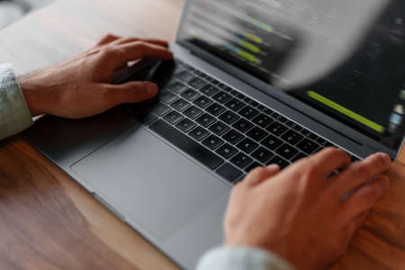 Young man using his laptop in cafe, close up