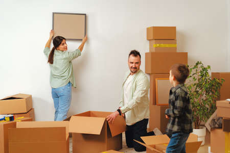 Young parents and son having fun during moving day to new house