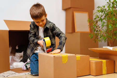 Little boy packing a moving box for a new homeの写真素材