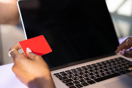 Close up of hand holding credit card and using laptopの写真素材
