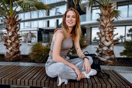 Young attractive woman sitting on bench in the cityの写真素材