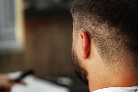 Young man client sitting in a barber shopの写真素材