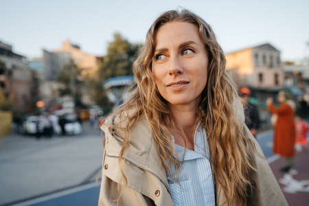 Portrait of a charming young woman posing for camera in the city