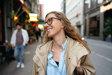 Portrait of Caucasian female business person in eyeglasses on city street