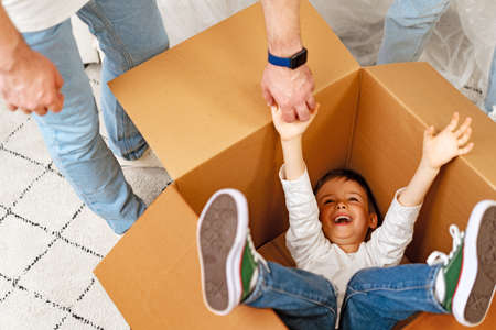 Little boy playing inside a moving box on a moving dayの写真素材