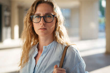 Portrait of Caucasian female business person in eyeglasses on city streetの写真素材