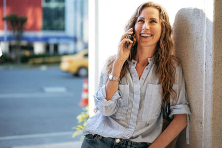 Young casual woman talking on the smartphone at the cityの写真素材