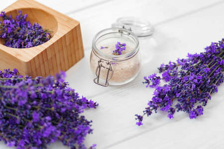 Lavender bath salt and dried flowers of lavender on white wooden backgroundの写真素材