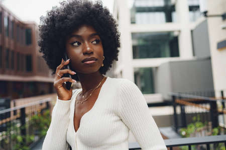 Black afro woman talking on mobile phone in the city