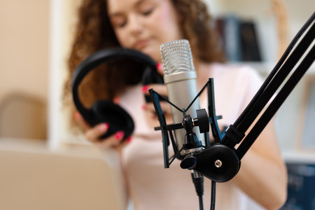 Woman vlogger looking at laptop and recording video with microphoneの写真素材