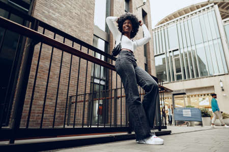 African young woman standing on city street outdoorsの写真素材