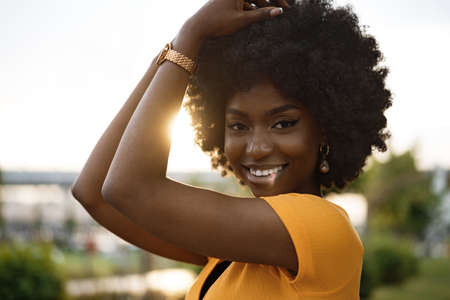Portrait of a young african american woman smiling standing at the city.の写真素材